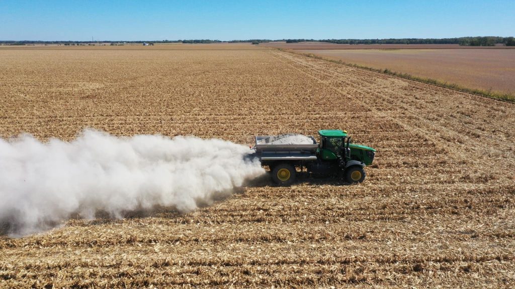 Truck spreading lime on field